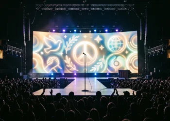 A conceptual depiction of a concert stage with peaceful symbols on a large screen.