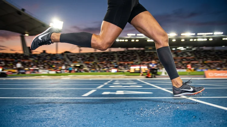 A close-up of a track anonymous silhouettes's legs in motion on a competition track.