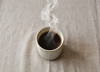 A steaming hot drink in a plain ceramic mug