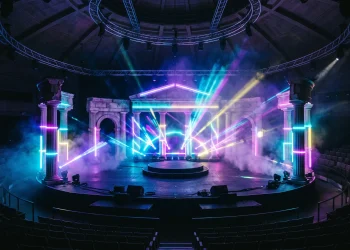 Conceptual image of a theatrical stage blending classical elements with 1990s rave lighting and neon colors.