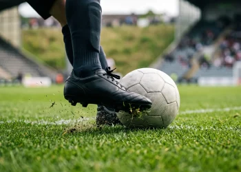 A close up of a goalkeeper kicking a football in a stadium