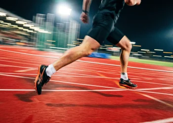 Low angle shot of a sprinter's legs in motion on a running track.