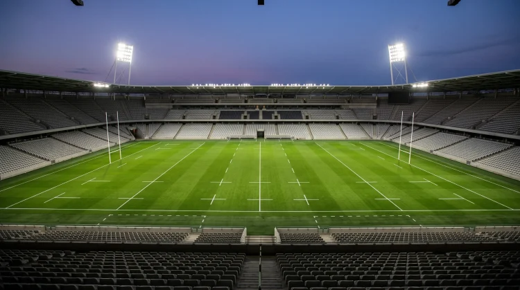 A professional rugby pitch under floodlights at night.