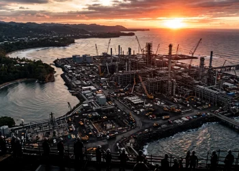 Aerial view of industrial construction on a coastline at dawn.